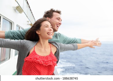 Romantic couple having fun laughing in funny pose on cruise ship boat. Smiling happy man and woman on travel vacation holidays on open ocean sea.