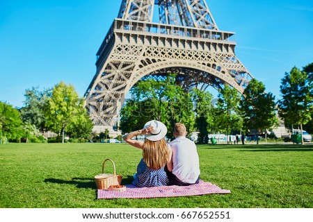 Romantic couple having picnic near the Eiffel tower in Paris, France