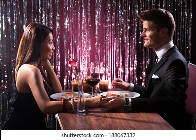 Romantic Couple Holding Each Other's Hand At Dinner In An Restaurant