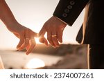 romantic couple holding hands fingers at sunset leaking wedding rings sunset rays bride groom wedding love couple golden hour 