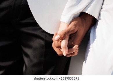 romantic couple holding hands at sunlight, black and white hand bride groom wedding love couple, hands of diverse races - Powered by Shutterstock