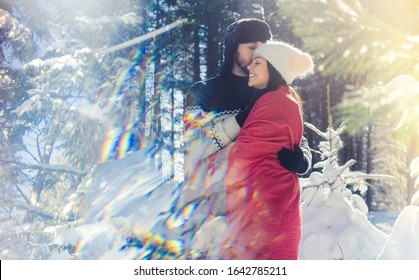 Romantic Couple Keeping Each Other Warm On Winter Hike In The Woods Full Of Snow