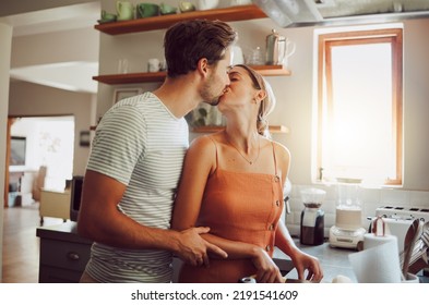 Romantic Couple Kissing, Cooking And Showing Affection In Love While Bonding Together In A Kitchen At Home. Caring Boyfriend And Girlfriend In A Loving Relationship Sharing An Intimate Special