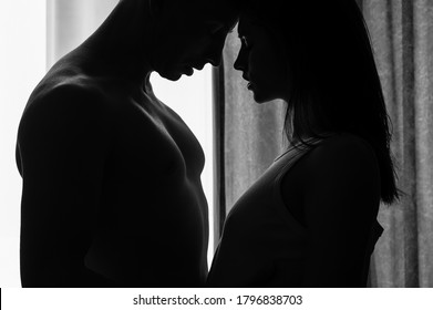 Romantic couple is kissing and enjoying the company of each other at home.