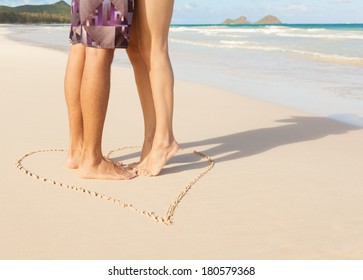 Romantic Couple Kissing On The Beach. Love - Male And Female Feet In The Heart On The Beach. 