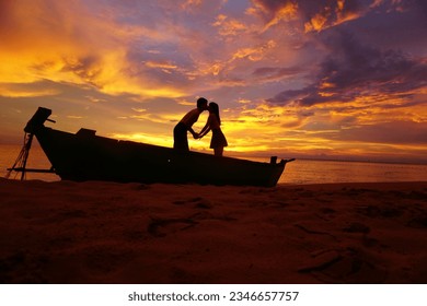 Romantic couple kissing on a wooden fishing boat at the coast during an amazing sunset. - Powered by Shutterstock