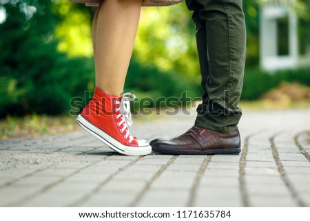 Romantic couple kissing outdoors - Lovers on a romantic date at sunset,girls stands on tiptoe to kiss her man - Close up on shoes.