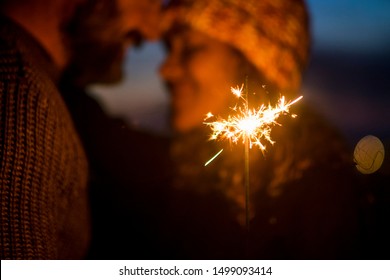 Romantic couple in love celebrate together the new year start or event party nightlife with fire sparkler - defocused people and close up composition with celebration concept - Powered by Shutterstock