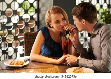 Romantic Couple In Love Drinking Cocktail From The Same Glass