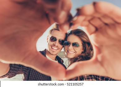 Romantic couple in love gesturing a heart with fingers