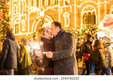 Romantic couple in love hugging and burning the sparklers at festive street fair - Powered by Shutterstock