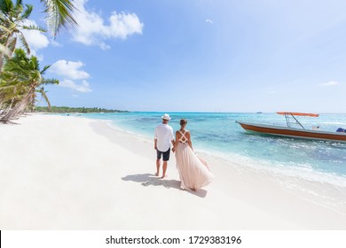 Romantic Couple In Love Hugging, Kissing And Running On The Sandy Tropical Caribbean Beach In Dominican Republic Landscape  