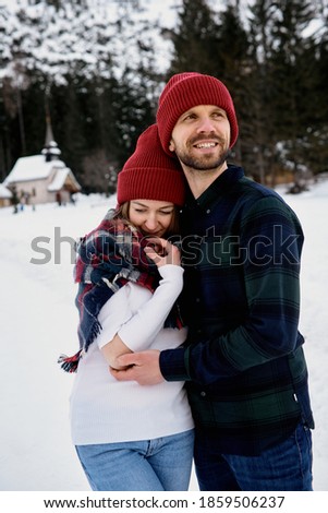 Romantic couple in love posing against the backdrop of majestic snow-capped mountains.