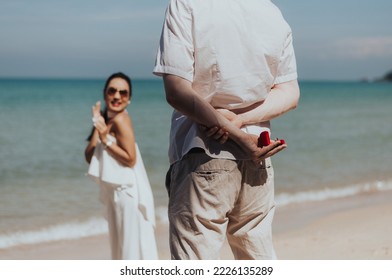 Romantic Couple Love Propose Marriage On The Beach. Young Boyfriend Surprising Get Marriage With Girlfriend On Summer Vacation. Honeymoon Lifestyle, Happy Aniversary.