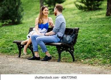 Romantic Couple In Love Sitting On Park Bench