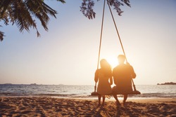 Pareja Romántica Enamorada Sentada En Una Cuerda Girando En La Playa Al Atardecer, Siluetas De Jóvenes Y Mujeres En Vacaciones O Luna De Miel