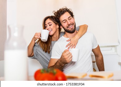 Romantic couple in love spending time together in kitchen. Cute young couple drinking coffee in kitchen and enjoying morning time together - Powered by Shutterstock