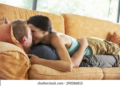 Romantic Couple Lying On Sofa At Home