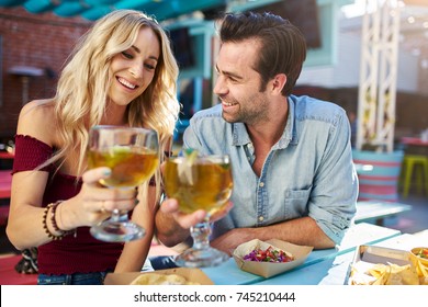 Romantic Couple Making Cheers With Beer At Outdoor Mexican Restaurant Eating Tacos