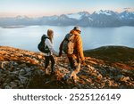 Romantic couple man and woman climbing mountains together active family adventure vacations - friends hiking with backpacks in Norway healthy lifestyle hiking tour outdoor 