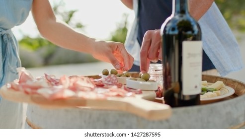 Romantic Couple, Man And Woman Toasting With Red Wine And Eating Finger Food Appetizer At Warm Sunset.Food Detail Shot. Friends Italian Trip In Umbria.4k Slow Motion