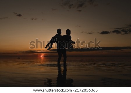 Romantic couple on the background of sunset near the ocean. Sunset walk along the ocean