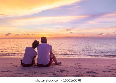 Romantic couple on the beach at colorful sunset on background. Perfect tropical sunset landscape, exotic nature view. Happy romantic couple enjoying beautiful sunset at the beach - Powered by Shutterstock