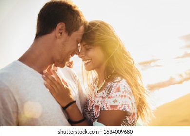 Romantic Couple On The Beach At Colorful Sunset.