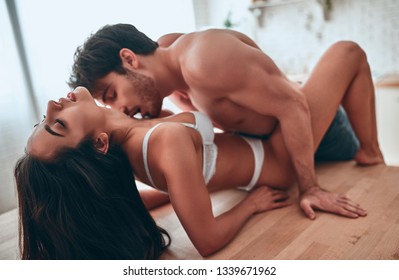 Romantic couple on kitchen. Attractive young woman and handsome bearded man having passionate sex on kitchen.