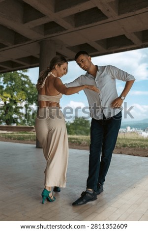 Romantic couple practicing partner dance outdoors, focused on posture, connection and graceful movement.