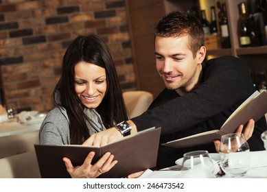 Romantic Couple At A Restaurant Looking At The Menu