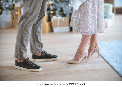 Romantic couple standing near Christmas tree at home and hugging - Shutterstock ID 2232378779