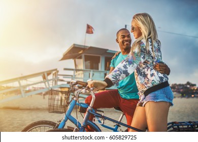 romantic couple watch sunset on santa monica beach after bike ride - Powered by Shutterstock