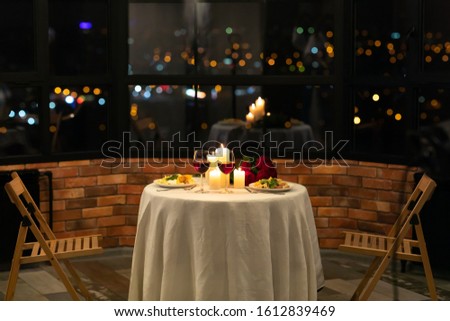 Romantic Date Dinner Concept. Served Table With Food And Burning Candles In Restaurant Interior At Night. No People
