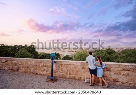 Romantic date in European capital. Couple in love stands at Budapest view point on sunset.