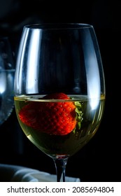 Romantic Date At Fancy Restaurant With Pinot Grigio White Wine With Strawberry Floating In Glass