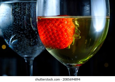 Romantic Date At Fancy Restaurant With Pinot Grigio White Wine With Strawberry Floating In Glass