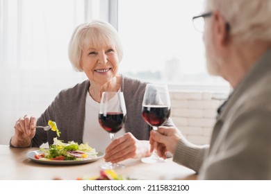 Romantic Date At Home. Anniversary Valentine`s Day Birthday Celebration. Happy Old Elderly Senior Couple Grandparents Drinking Wine Having Dinner At Home Kitchen Together