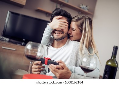 Romantic Date.Young Woman Giving A Gift To Her Boyfriend.