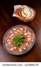 Romantic Dinner With Carpaccio Cold Meat Cattail Basket Of Artisan Breads Basil Leaves Dijon Mustard Glass Of White Wine Wooden Table Top View Portrait