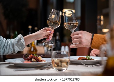 Romantic Dinner. Couple Cheers With White Wine