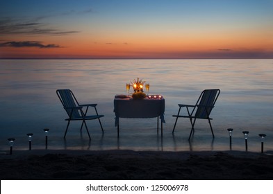 Romantic Dinner On The Sea Beach With Candles And Wine