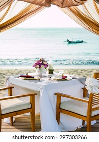 Romantic Dinner Setting On The Beach At Sunset