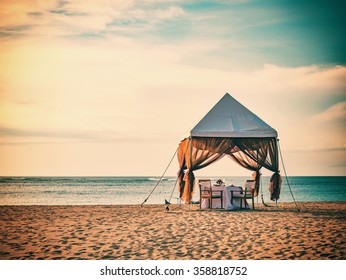 Romantic Dinner Setting On The Beach At Sunset