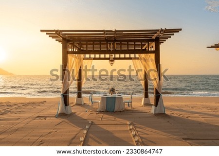 Romantic dinner setting on the beach at sunset. Dinner table