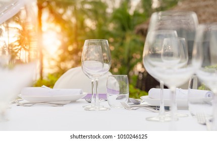 Romantic dinner setting at pool with sunset on the beach