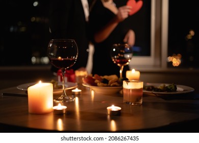romantic dinner setting, red wine in glasses and candles, date for two, Valentine's Day evening, burning candles on the table, close-up - Shutterstock ID 2086267435