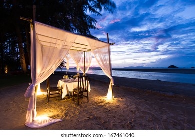 Romantic Dinner Setup On The Beach While Twilight