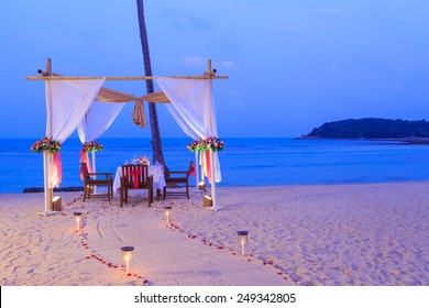 Romantic Dinner Setup On The Beach While Twilight