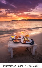 Romantic Dinner Table set beside the beach in the sunset twilight time